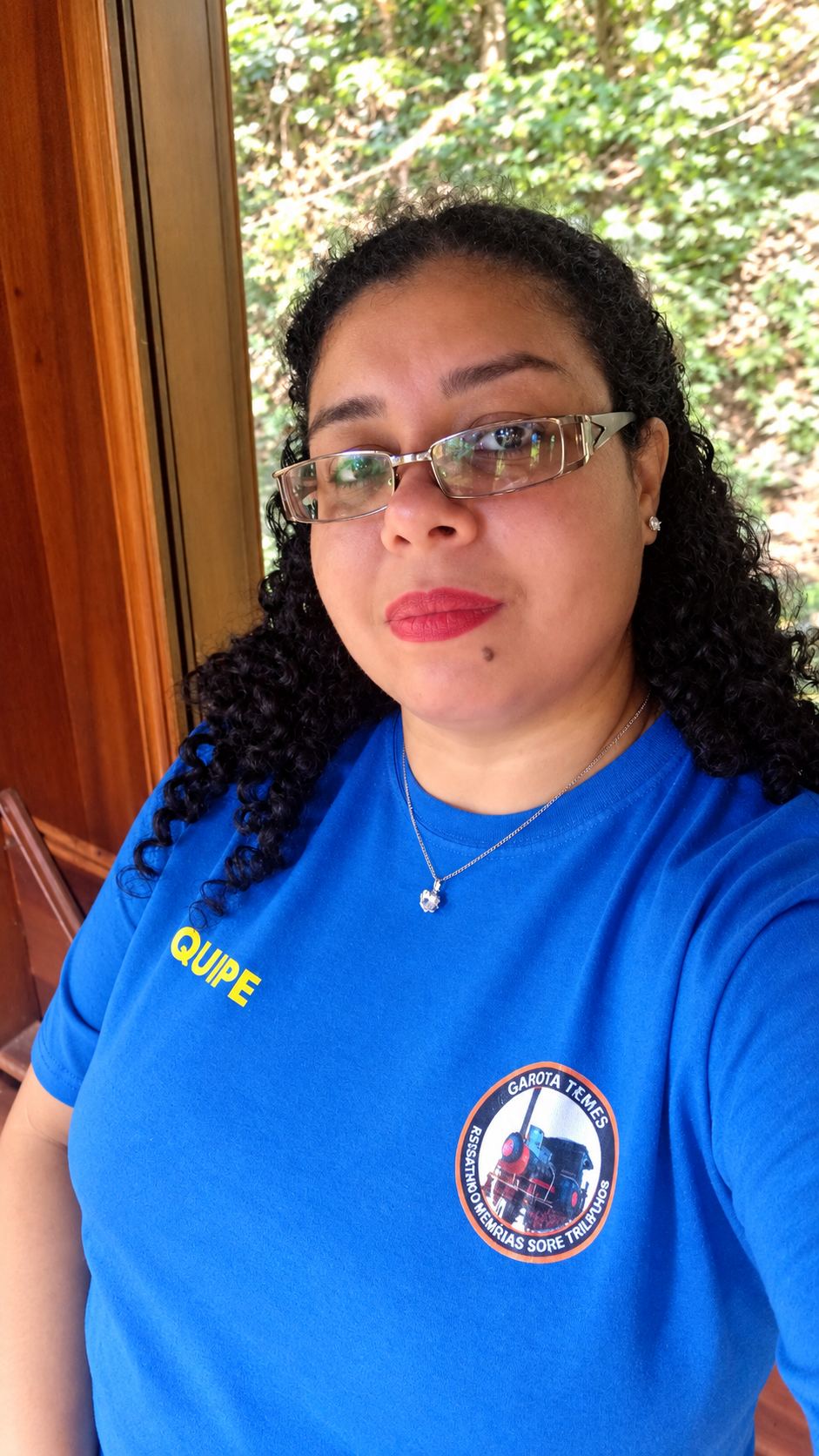 Érika com a camiseta da equipe em passeio de trem