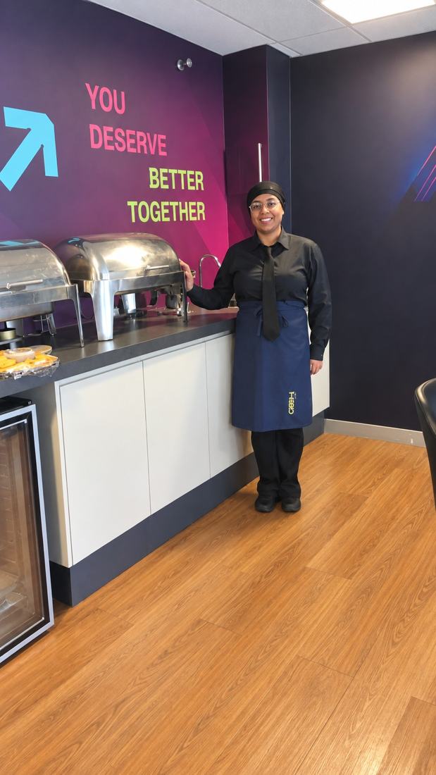 Érika ao lado do buffet em um evento corporativo